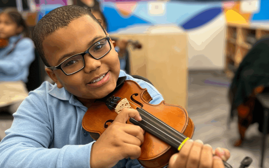 Young student playing a violin during a music lesson.