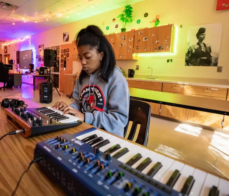A young girl playing an electric piano.
