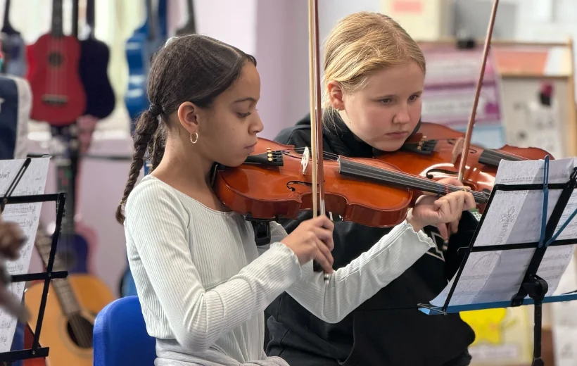 Students playing violin in an ensemble